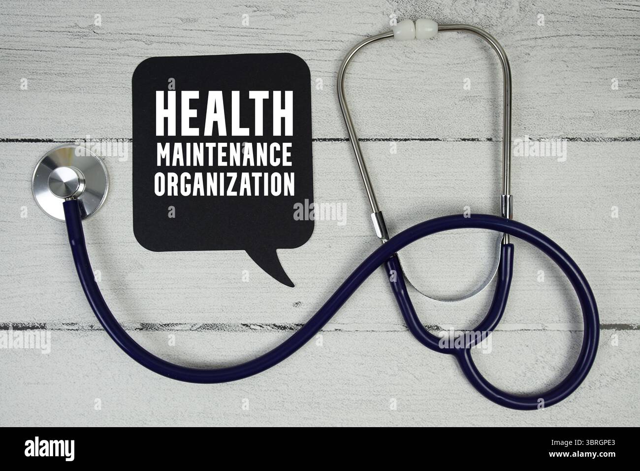 HMO Health Maintenance Organization Text mit medizinischem Stethoskop auf hölzernem Hintergrund Stockfoto
