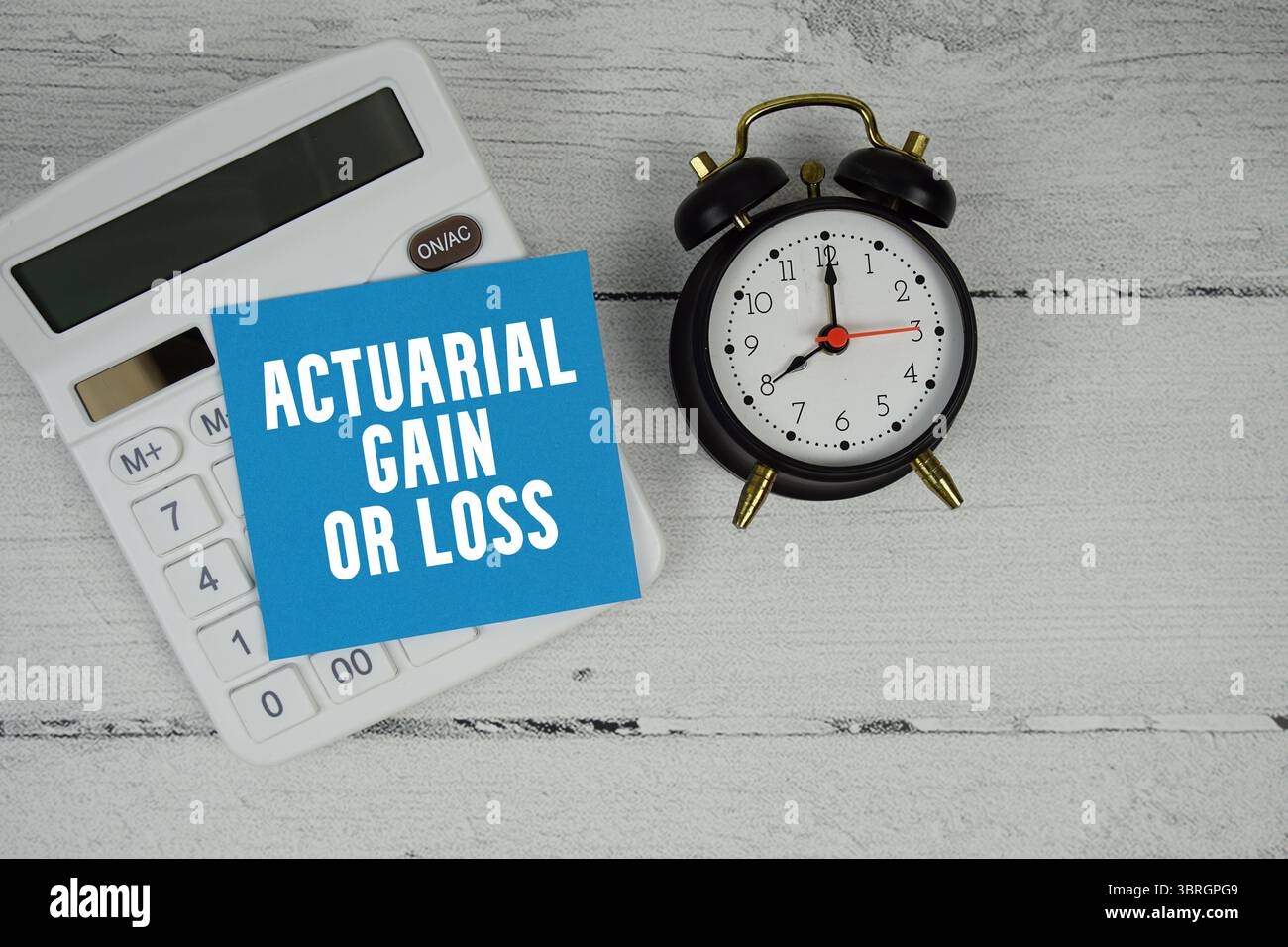 Text für versicherungsmathematische Verstärkung oder Verlust mit Rechner und Wecker auf hölzernem Hintergrund Stockfoto