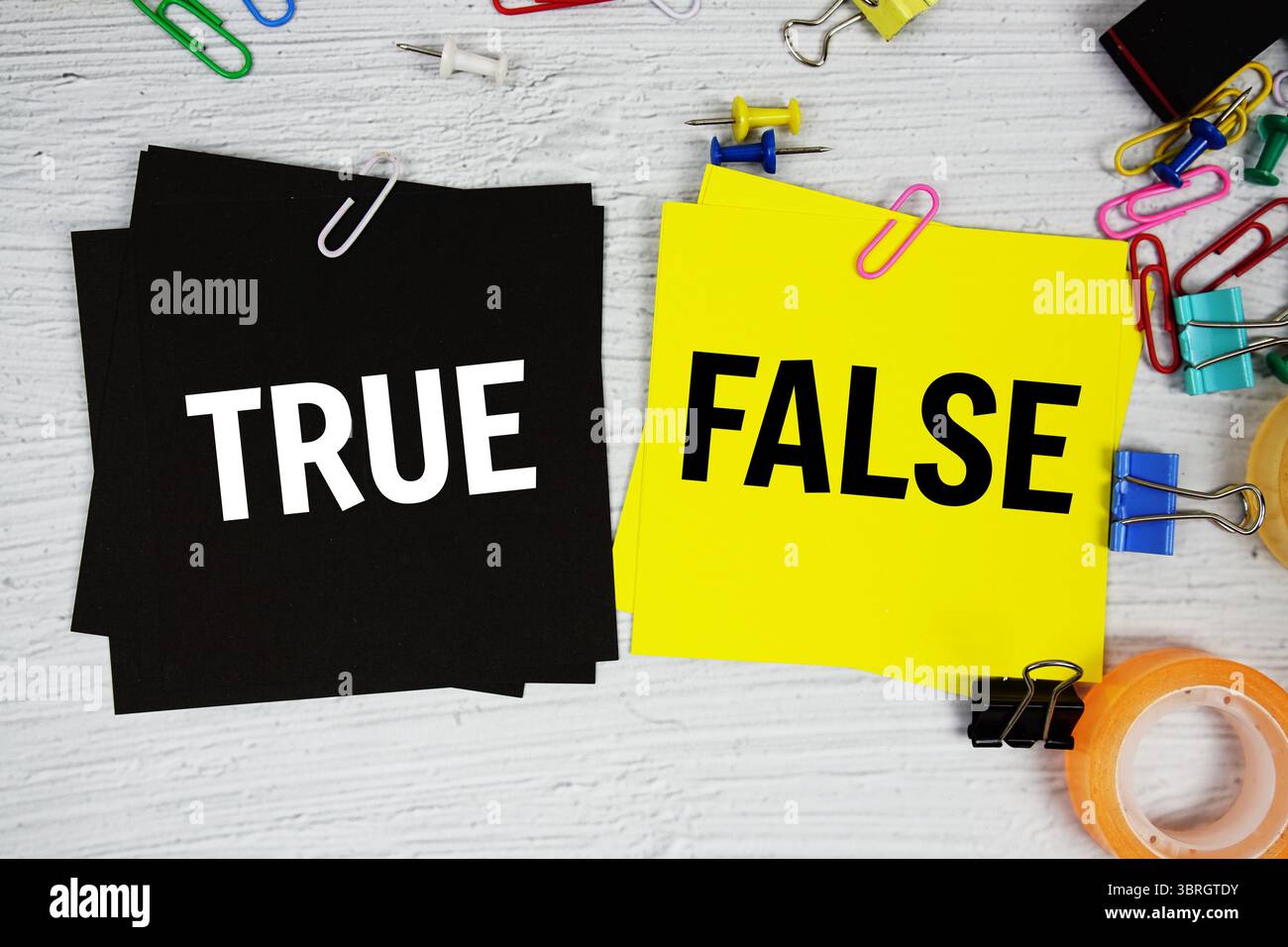 Richtig oder falsch Text auf Haftnotiz mit Briefpapier auf konkretem Hintergrund Stockfoto