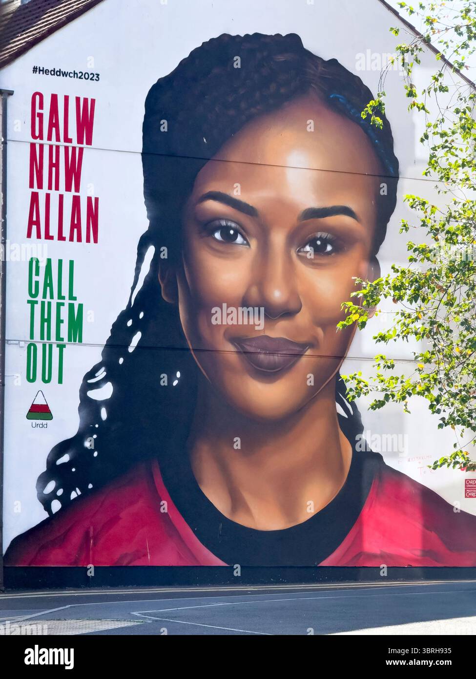 „Call them Out“-Wandgemälde in Cardiff Bay mit Urdd-Botschafterin Nia Fajeyisan, Wales, Vereinigtes Königreich - Smartphone-aufgenommenes Stockfoto
