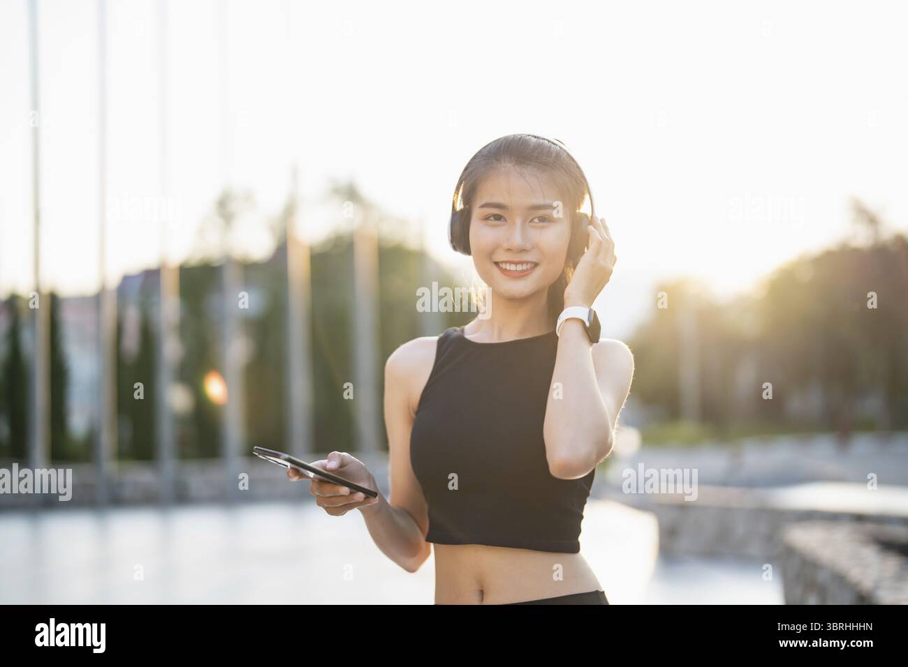 Happy Active Healthy asian Woman hört Musik mit Kopfhörern für geistige Gesundheit Hören von Audio für Laufen Inspiration Stockfoto