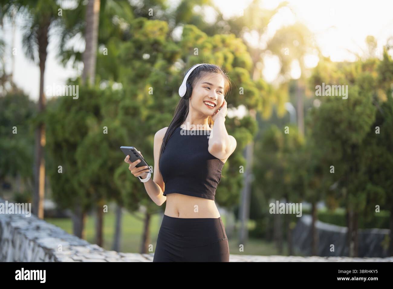 Happy Active Healthy asian Woman hört Musik mit Kopfhörern für geistige Gesundheit Hören von Audio für Laufen Inspiration Stockfoto