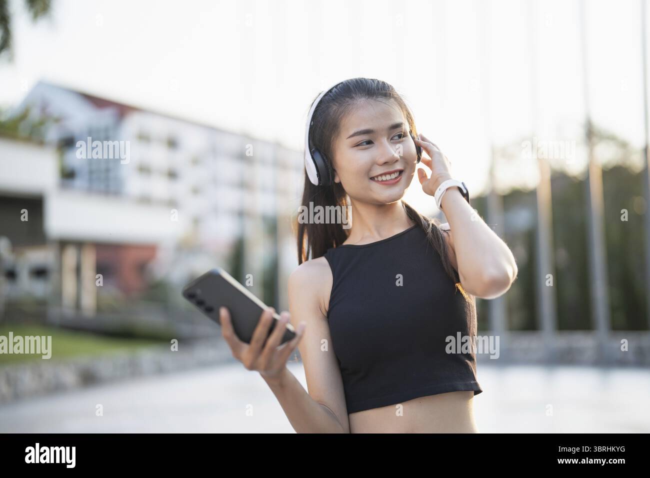 Happy Active Healthy asian Woman hört Musik mit Kopfhörern für geistige Gesundheit Hören von Audio für Laufen Inspiration Stockfoto