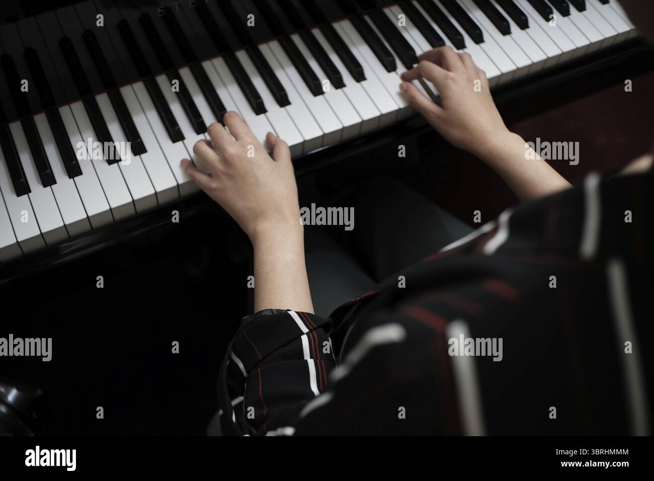 Schöne asiatische Mädchen lernen, Klavier zu spielen Stockfoto