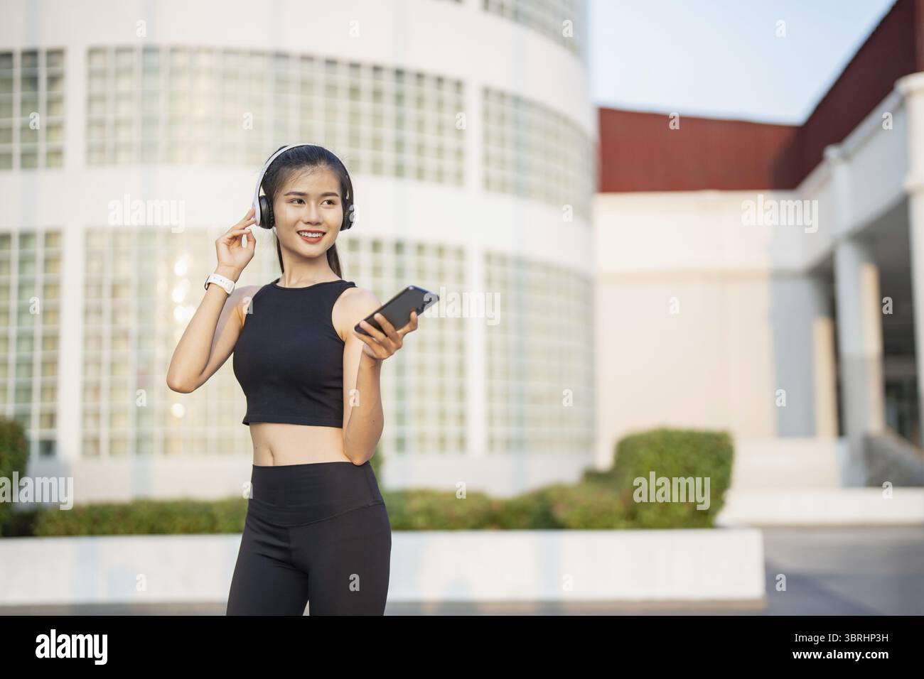 Happy Active Healthy asian Woman hört Musik mit Kopfhörern für geistige Gesundheit Hören von Audio für Laufen Inspiration Stockfoto