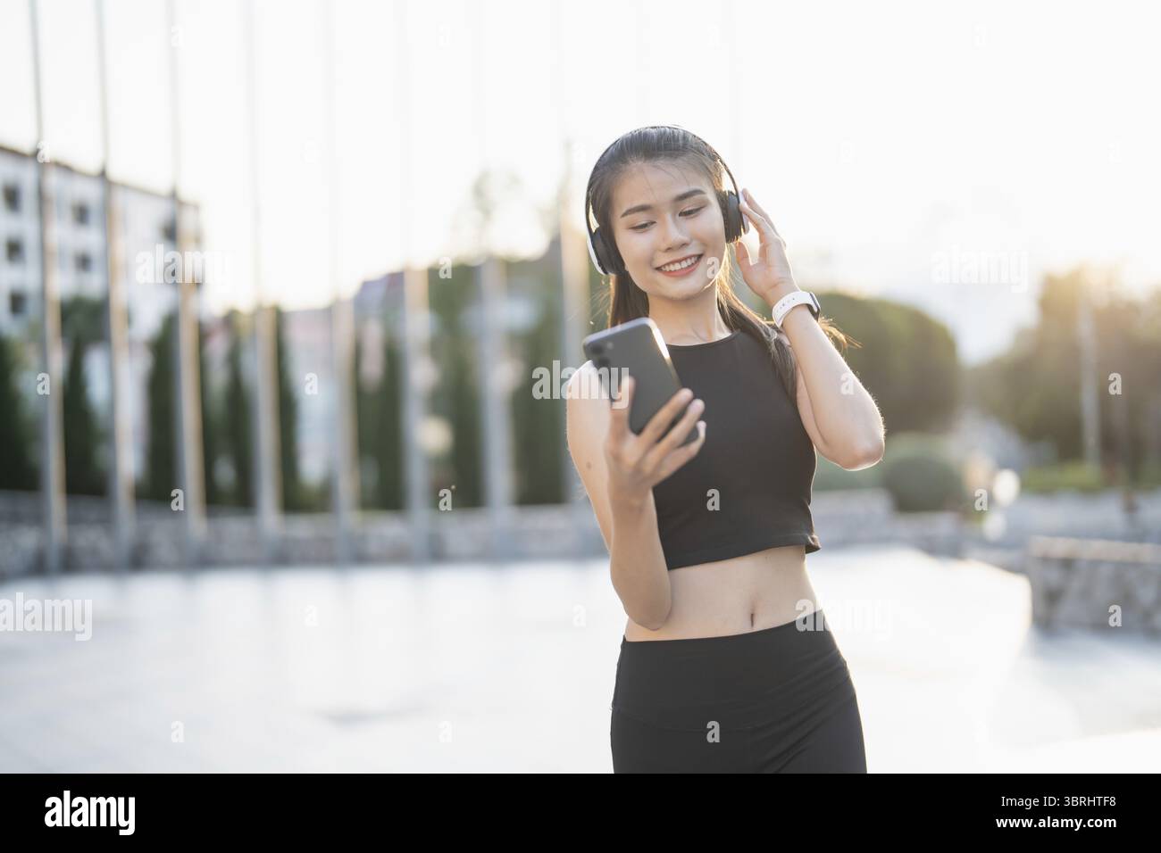 Happy Active Healthy asian Woman hört Musik mit Kopfhörern für geistige Gesundheit Hören von Audio für Laufen Inspiration Stockfoto