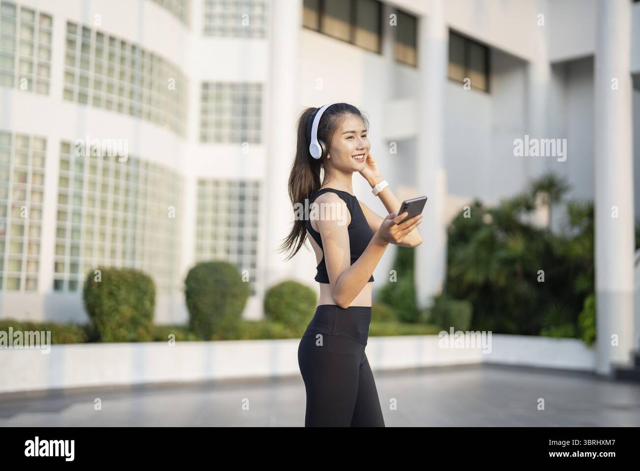 Happy Active Healthy asian Woman hört Musik mit Kopfhörern für geistige Gesundheit Hören von Audio für Laufen Inspiration Stockfoto