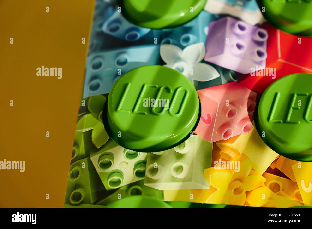 Tyumen, Russland-8. Juli 2025: Grünes Gebäude Lego-Block ruht auf einem farbenfrohen Hintergrund mit verspielten Designs Stockfoto