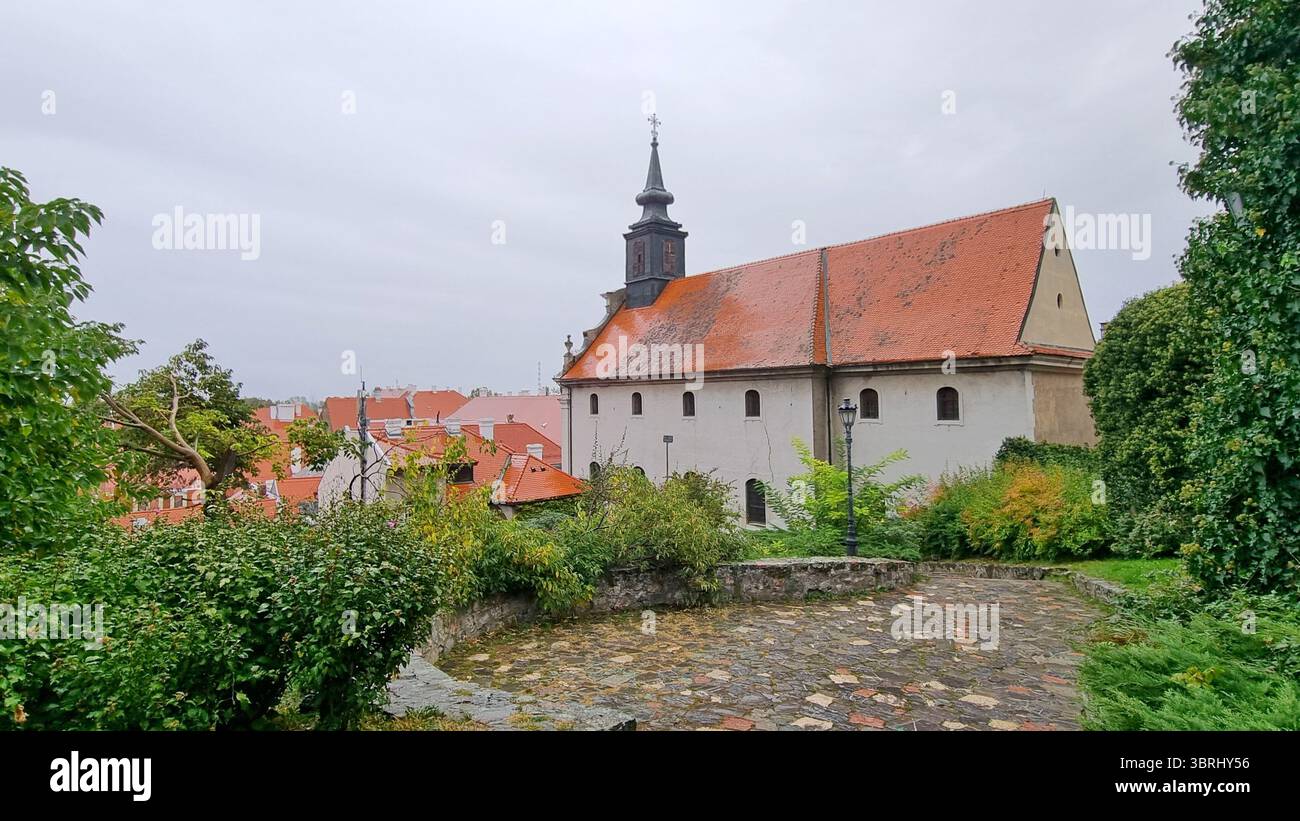 Blick auf die antike barocke römisch-katholische Kirche St. Georg an einem regnerischen Tag in Petrovaradin, Serbien Stockfoto