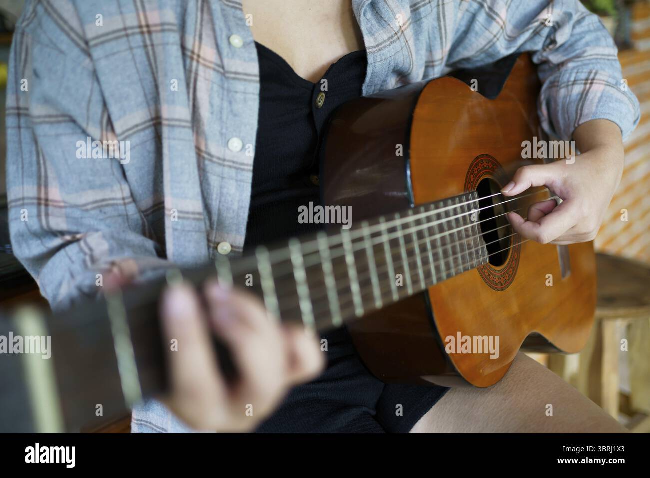 Fröhliche junge Frauenhände spielen Akustikgitarrenmusiker allein komponieren instrumentale Songstunden beim Gitarrenspielen Stockfoto