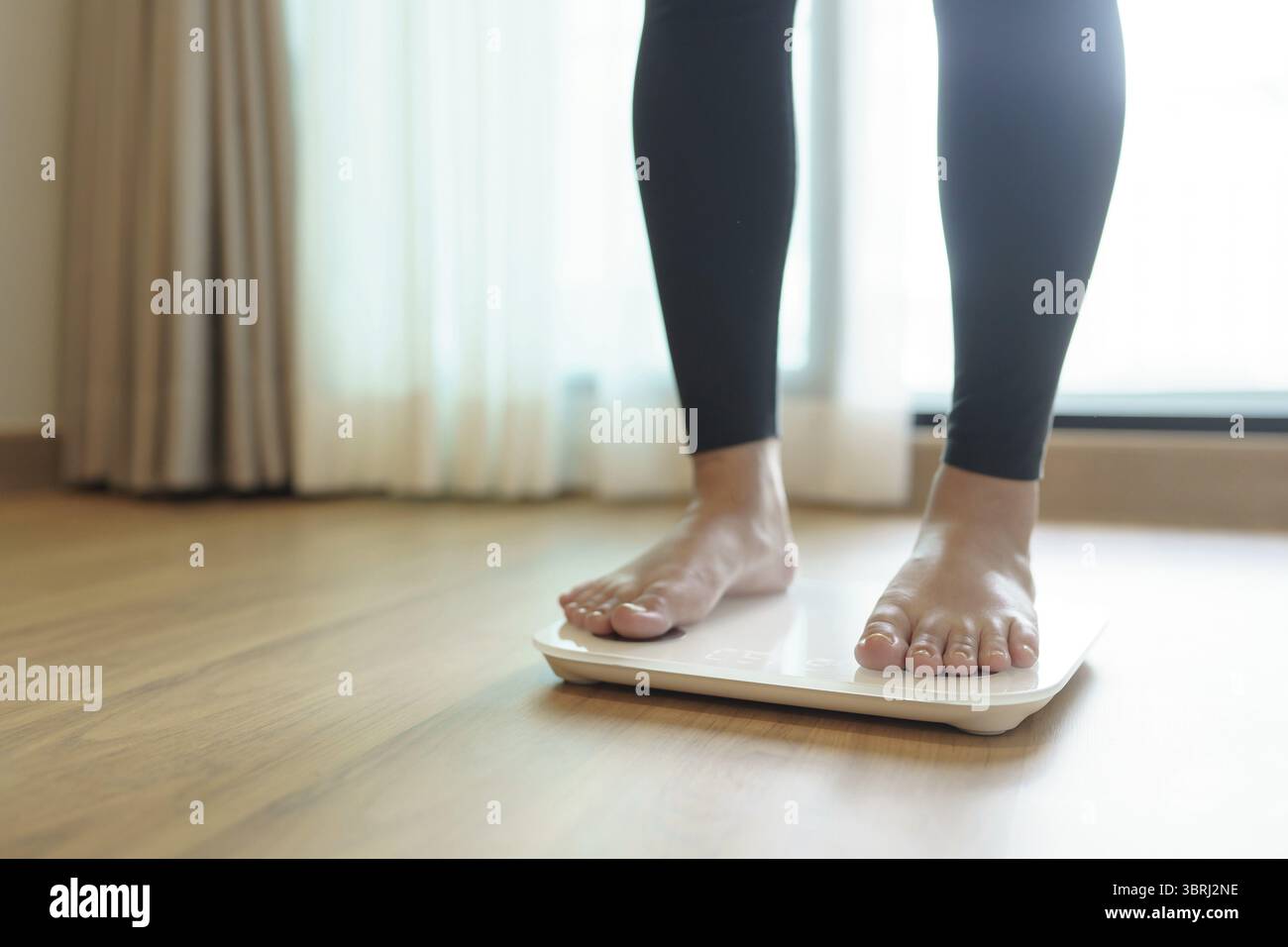 Abnehmen. Fettdiät und Schuppenfüße stehen auf elektronischen Waagen zur Gewichtskontrolle. Messgerät in Kilogramm für Diät Stockfoto