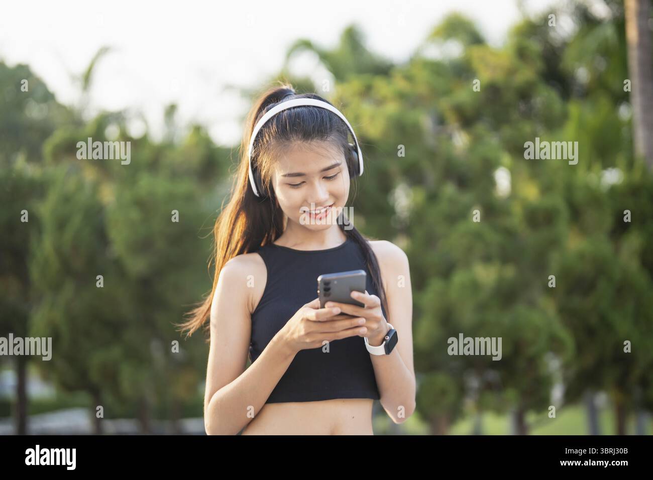 Happy Active Healthy asian Woman hört Musik mit Kopfhörern für geistige Gesundheit Hören von Audio für Laufen Inspiration Stockfoto