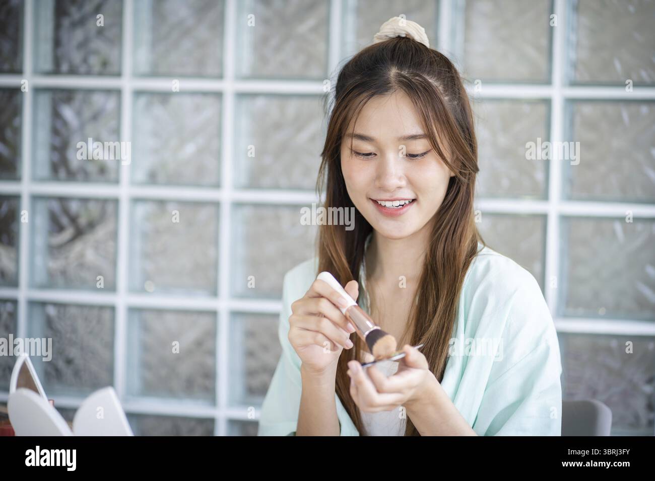Beauty Influencer asiatische Mädchen Make-up Künstlerin empfiehlt Foundation Kosmetik. Frau Blogger Vlogger Video Beauty Influencer asiatische Mädchen Video online märz Stockfoto