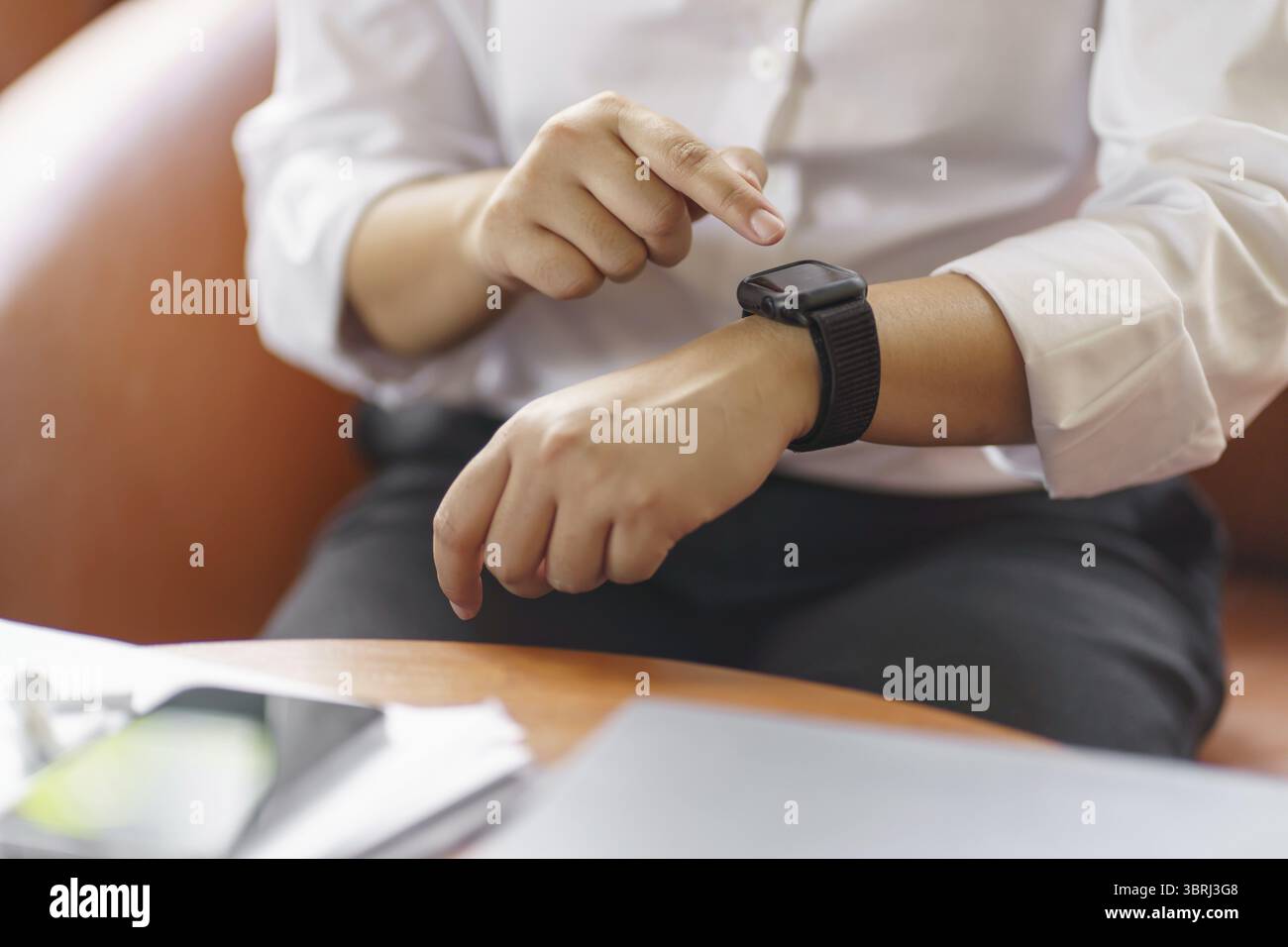 Geschäftsfrau mit Blick auf Smart Watch in der Office Online Connect Gadget-Technologie Stockfoto