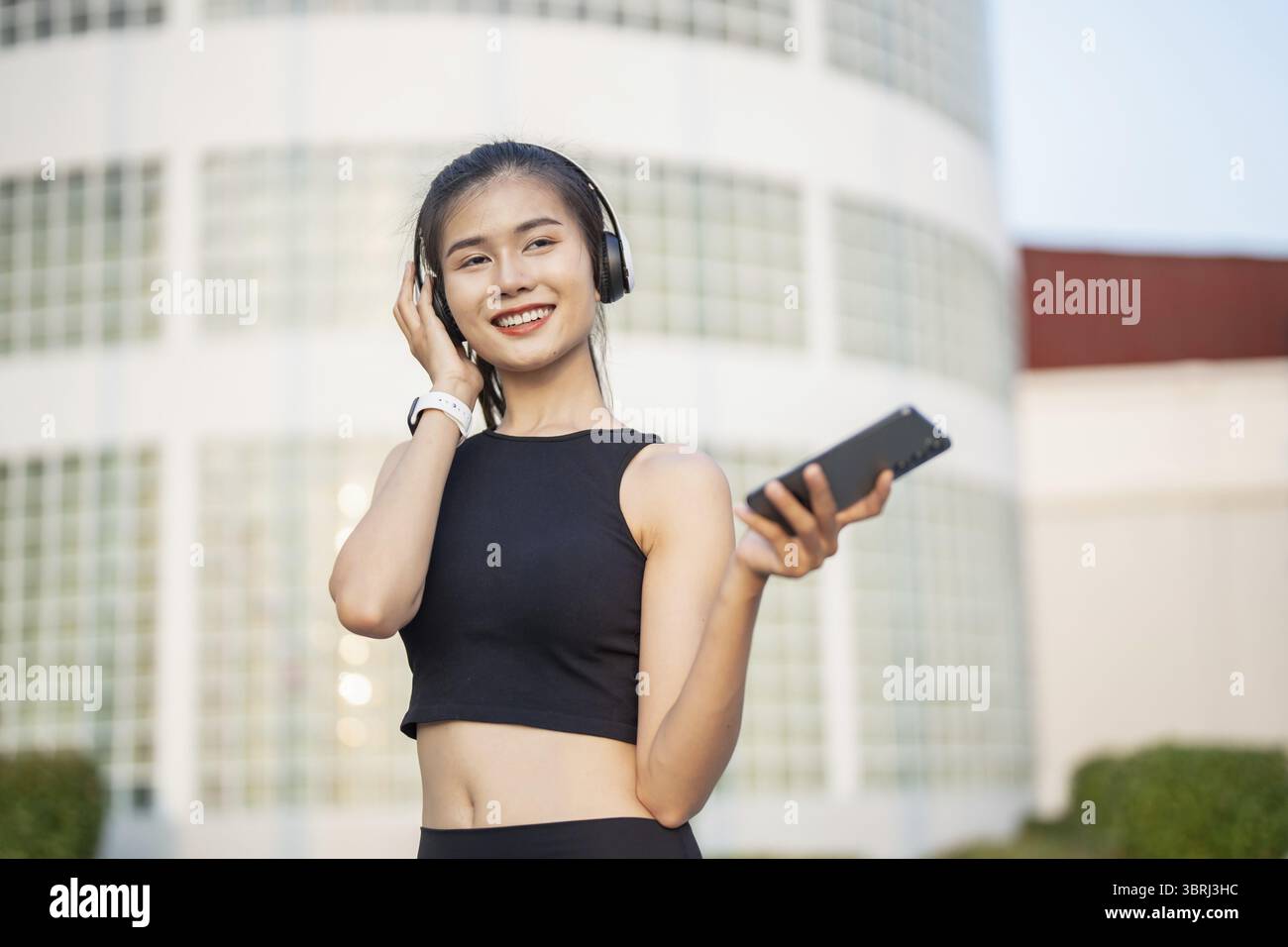 Happy Active Healthy asian Woman hört Musik mit Kopfhörern für geistige Gesundheit Hören von Audio für Laufen Inspiration Stockfoto