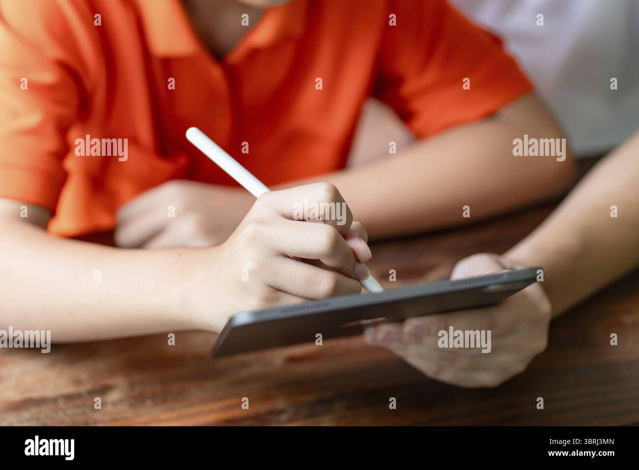 Asiatischer Vater und Sohn mit Tablet lernen Sohn Zeichnen mit digitalem Tablet am Schreibtisch Vaterschaft-Konzept Stockfoto