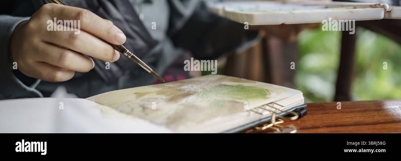 Student im Kunststudio. Hand haltender Künstler Pinsel mischen FarbÖlgemälde auf Palette Kunst Kreativität und Menschen Konzept Stockfoto