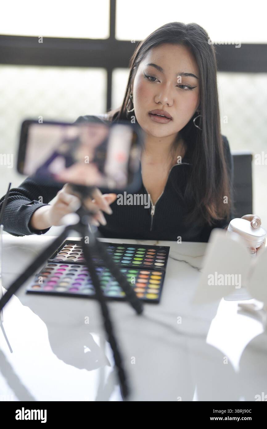 Asiatische Mädchen Make-up Künstlerin professionelle Frau Blogger Vlogger zeigt Kosmetik Produkte mit Aufnahme Video Beauty Influencer asian Girl Video onli Stockfoto