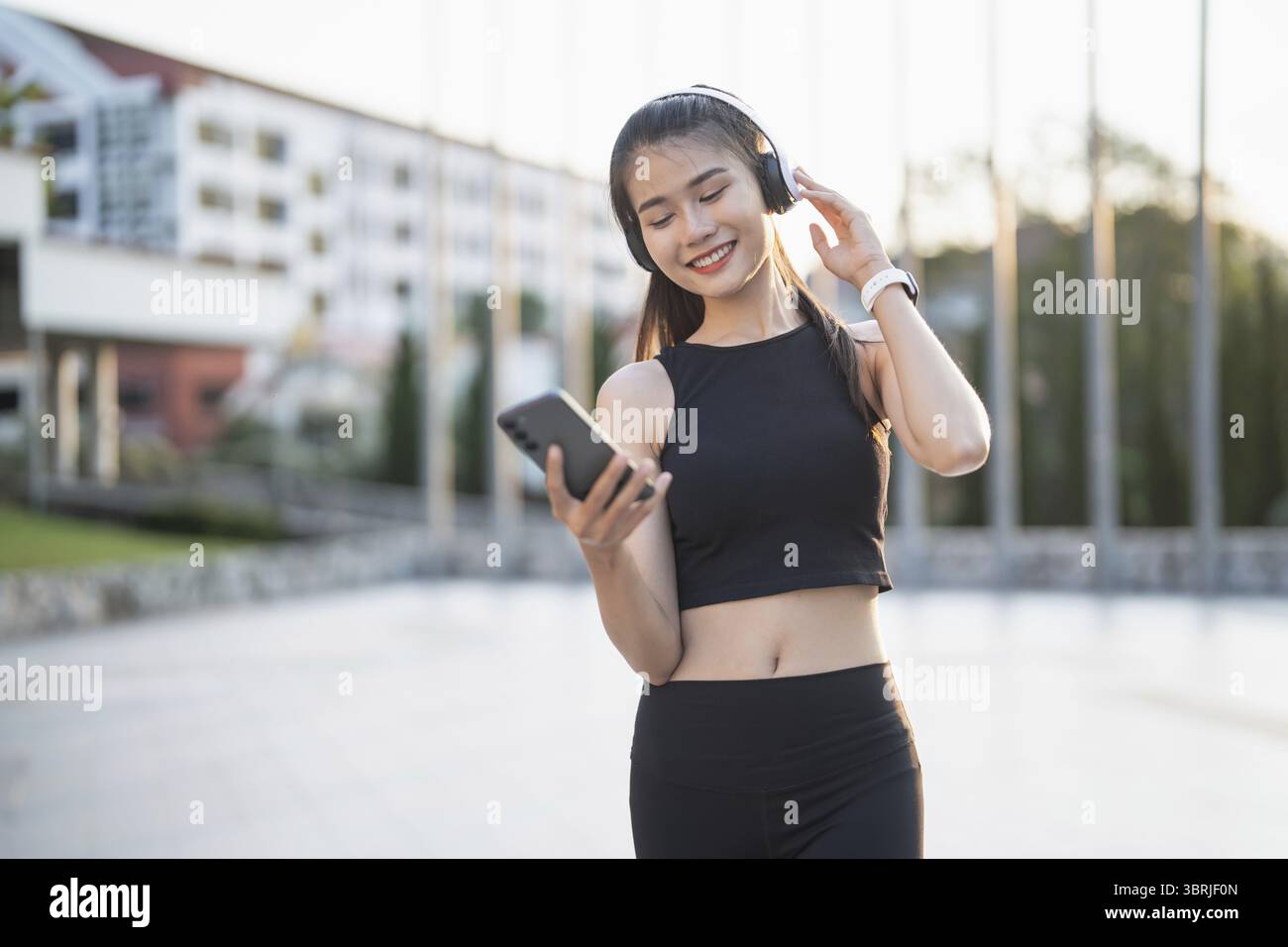 Happy Active Healthy asian Woman hört Musik mit Kopfhörern für geistige Gesundheit Hören von Audio für Laufen Inspiration Stockfoto