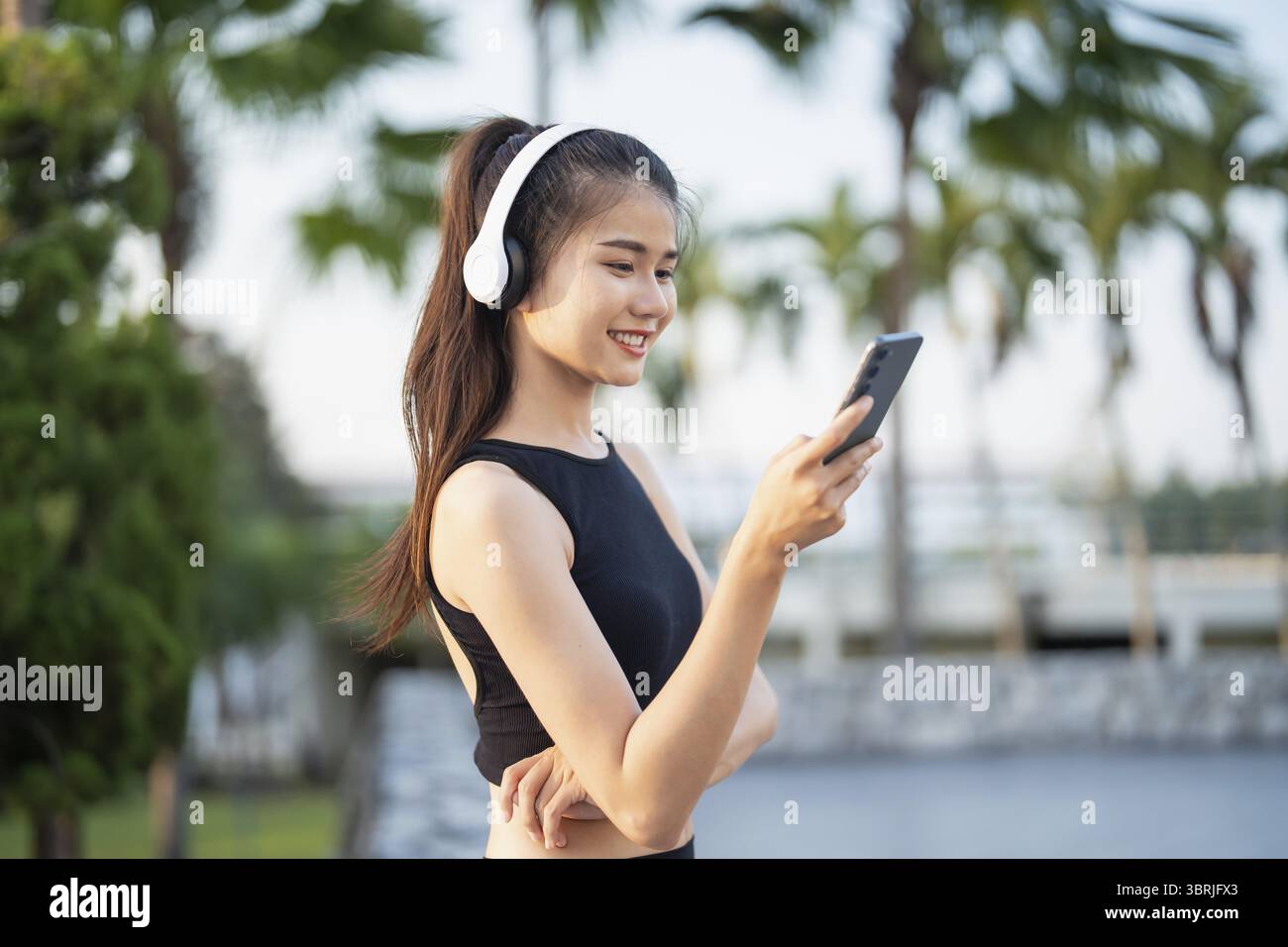Happy Active Healthy asian Woman hört Musik mit Kopfhörern für geistige Gesundheit Hören von Audio für Laufen Inspiration Stockfoto