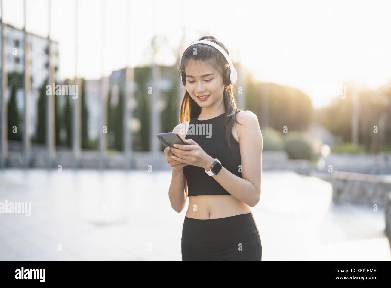 Happy Active Healthy asian Woman hört Musik mit Kopfhörern für geistige Gesundheit Hören von Audio für Laufen Inspiration Stockfoto