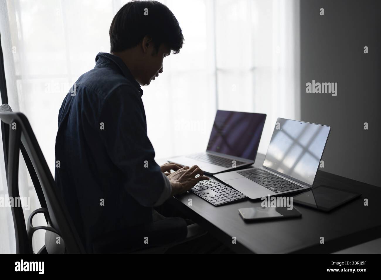 Asiatischer Mann Software-Ingenieur arbeitet am Computer am Bürotisch zum Schreiben von Programmcode IT Software Engineer Finden von Fehlern technischer Support devops erstellt Stockfoto