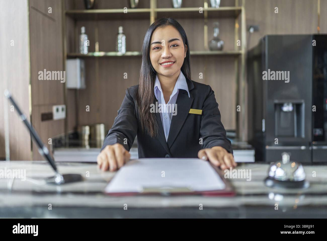 Wunderschöne asiatische Hotelrezeptionistin in Uniformen an der Rezeption in der Lobby freundliches und freundliches Personal an der Rezeption Stockfoto