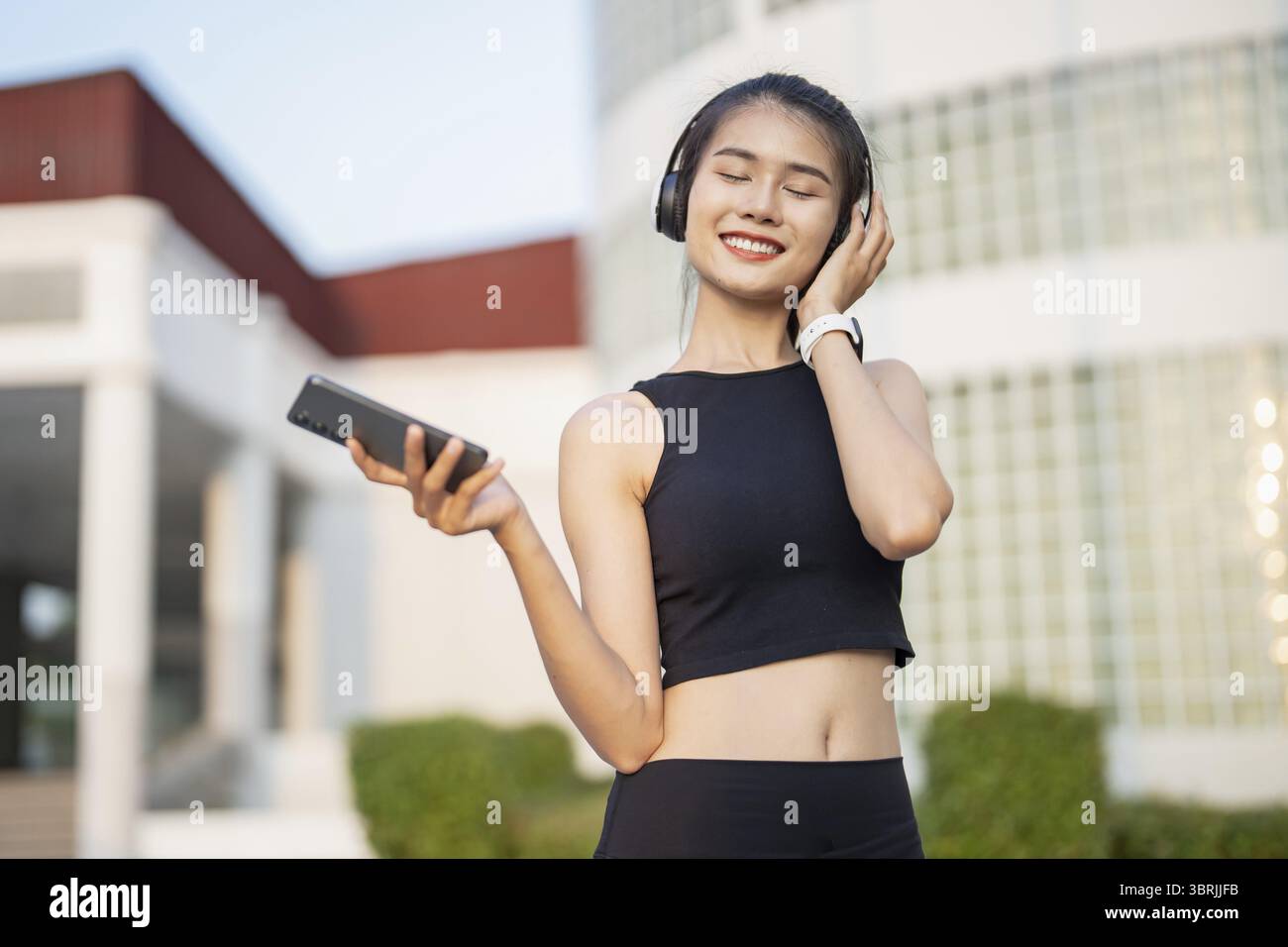 Happy Active Healthy asian Woman hört Musik mit Kopfhörern für geistige Gesundheit Hören von Audio für Laufen Inspiration Stockfoto