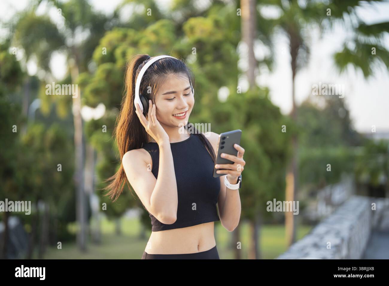 Happy Active Healthy asian Woman hört Musik mit Kopfhörern für geistige Gesundheit Hören von Audio für Laufen Inspiration Stockfoto