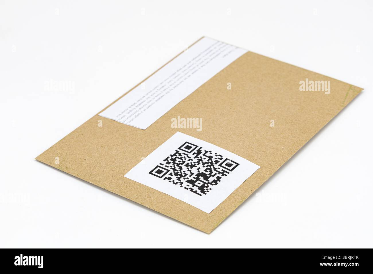 Ein brauner Umschlag mit qr-Code-Etikett wird auf einer weißen Oberfläche angebracht und zeigt eine moderne und effiziente Art, Informationen auszutauschen. Einfaches Design des Kuverts Stockfoto