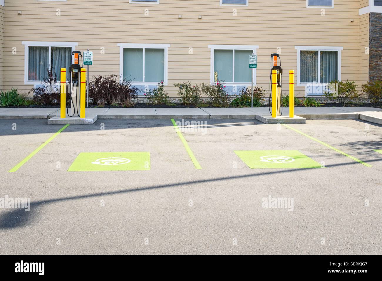 Leere Ladestation für Elektroautos hinter einem Gebäude an einem sonnigen Tag Stockfoto