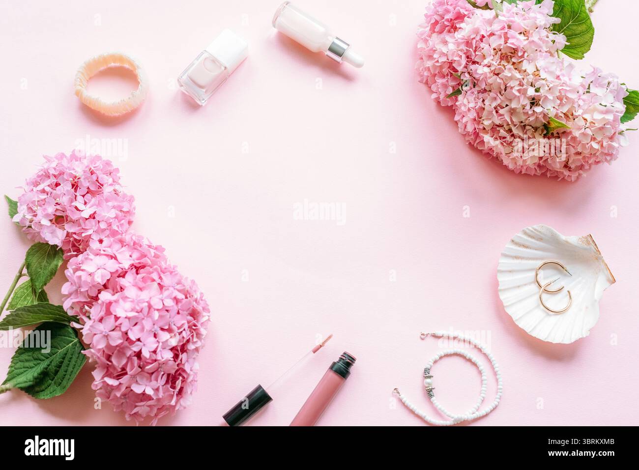 Rosa Hortensie Blumen mit nagellack, Lippengloss und Schmuck auf weichem Pastellhintergrund. Draufsicht, flach, Kopierbereich. Stockfoto