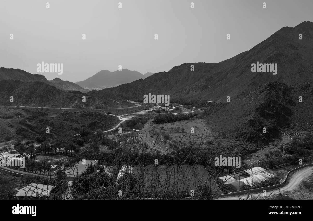 Schwarzweiß-Filmaufnahmen von Bergketten und Talblick, trockenen Wüstenbergen in den Vereinigten Arabischen Emiraten Stockfoto