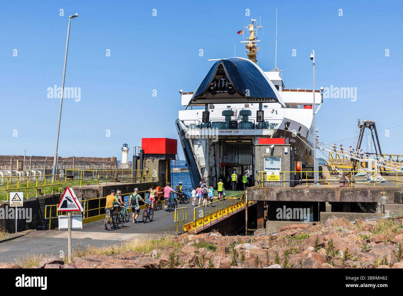 Radfahrer gehen an Bord der MV Isle of Arran, Eilean Arainn in Gälisch, im Besitz von Caledonian MacBrayne Anlegeplatz am Ardrossan Pier, Ayrshire, Schottland, Großbritannien Stockfoto
