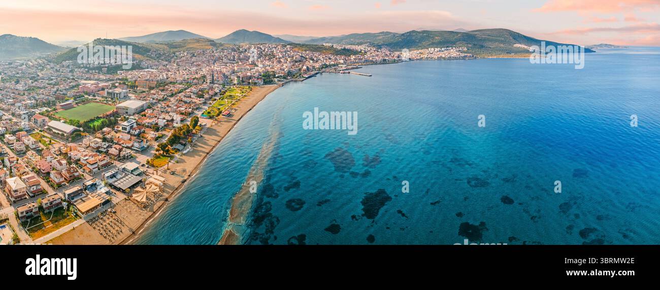 Atemberaubender Blick aus der Luft auf die Küste von Dikili, gebadet in den warmen Glanz des Sonnenuntergangs, mit Blick auf das wunderschöne türkisfarbene Wasser der Ägäis Stockfoto