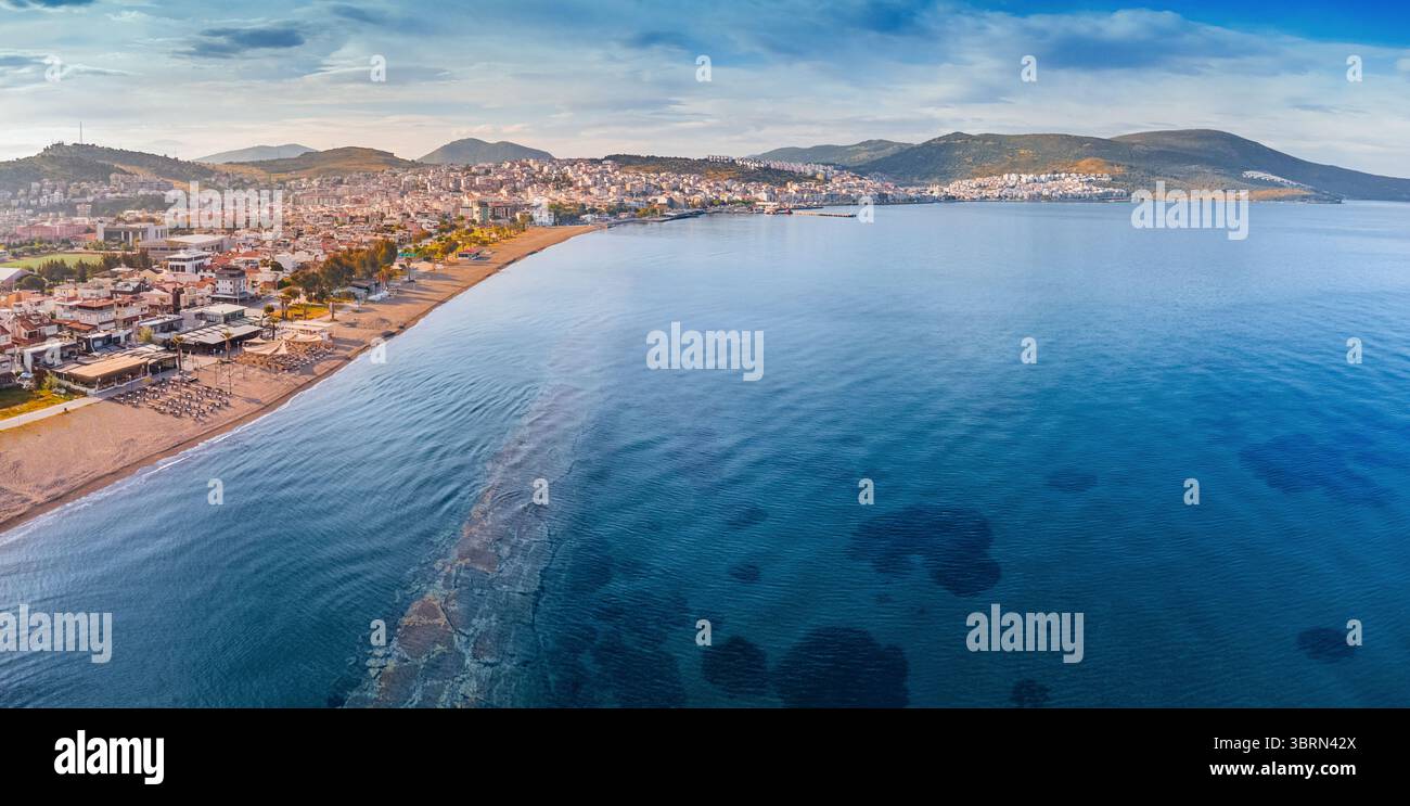 Atemberaubender Blick aus der Luft auf die Küste von Dikili, gebadet in den warmen Glanz des Sonnenuntergangs, mit Blick auf das wunderschöne türkisfarbene Wasser der Ägäis Stockfoto