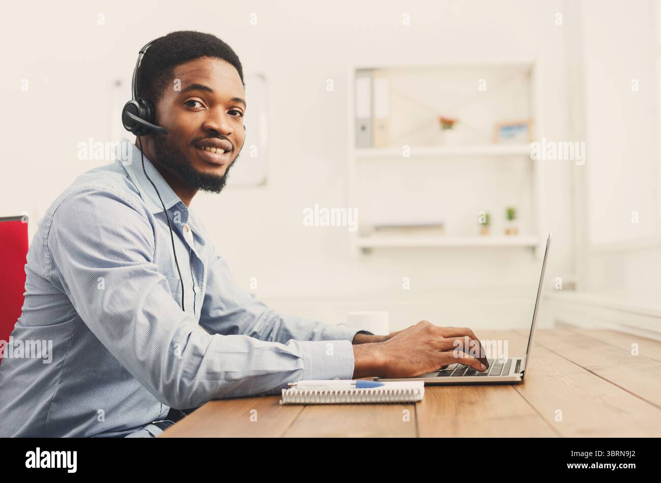 Callcenter-Mitarbeiter mit Headset Stockfoto
