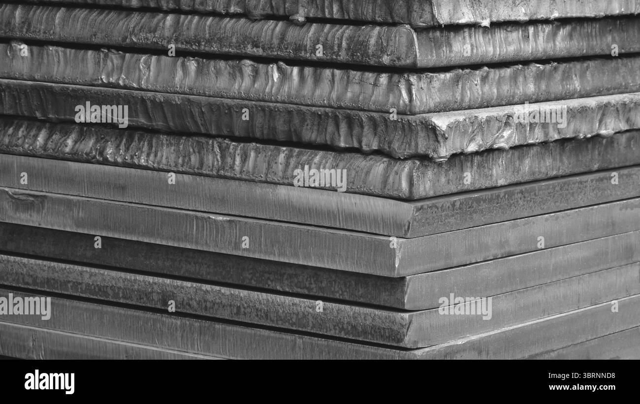 Stapel schwarzer dicker Schwermetallplatten rostige, unebene Oberfläche nach Laserschneiden. Platten übereinander gestapelt, wodurch Tiefe und Textur des SENSE erzeugt werden. sce Stockfoto