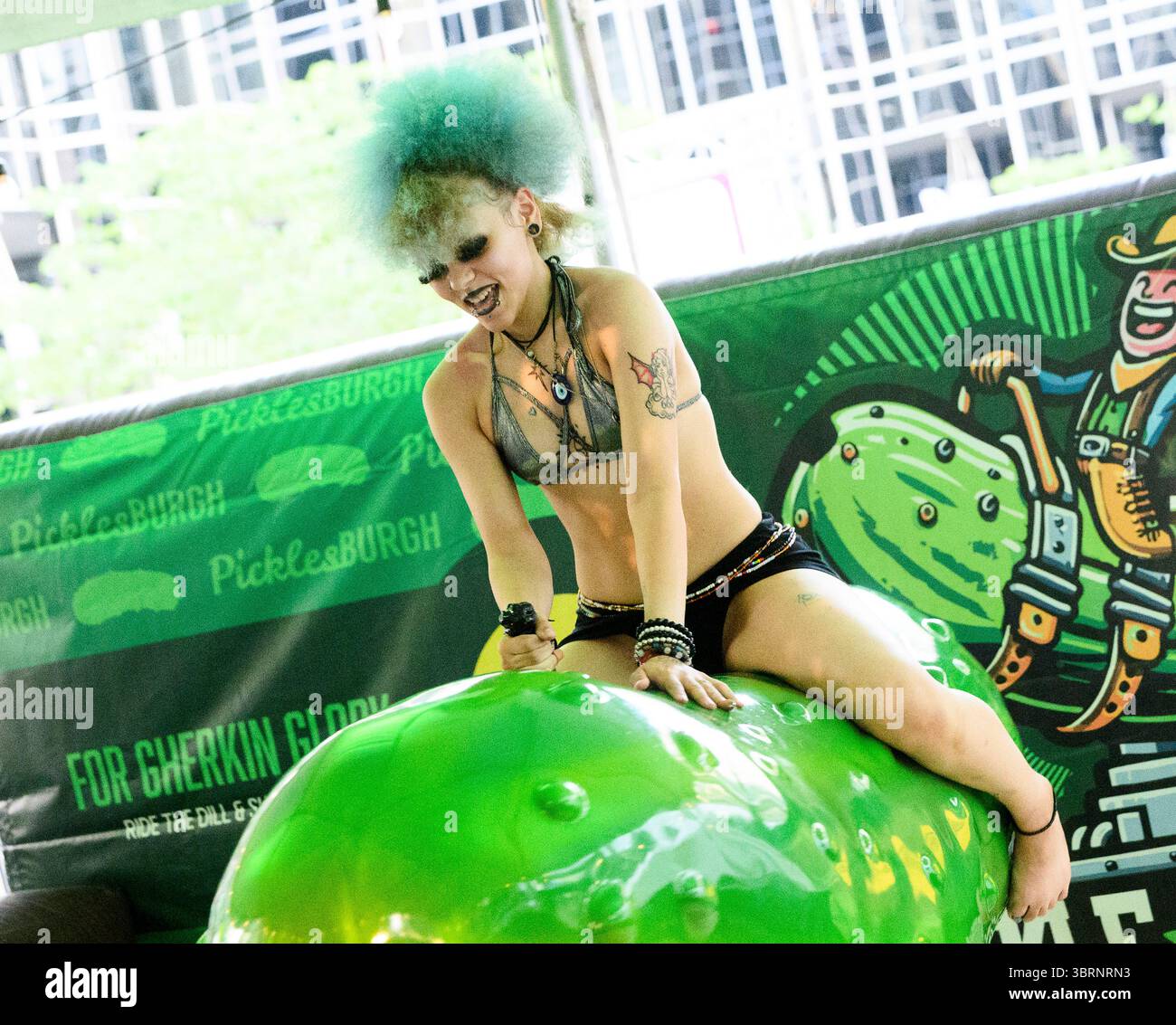 Pittsburgh, Usa. Juli 2025. Besucher des Picklesburgh-Events versuchen ihr Glück beim Fahren einer Mechanik im Rahmen des zehnten Jubiläums von Picklesburgh am Sonntag, den 13. Juli 2025 in der Innenstadt von Pittsburgh. Foto: Archie Carpenter/UPI Credit: UPI/Alamy Live News Stockfoto