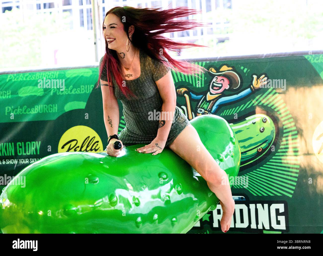 Pittsburgh, Usa. Juli 2025. Besucher des Picklesburgh-Events versuchen ihr Glück beim Fahren einer Mechanik im Rahmen des zehnten Jubiläums von Picklesburgh am Sonntag, den 13. Juli 2025 in der Innenstadt von Pittsburgh. Foto: Archie Carpenter/UPI Credit: UPI/Alamy Live News Stockfoto