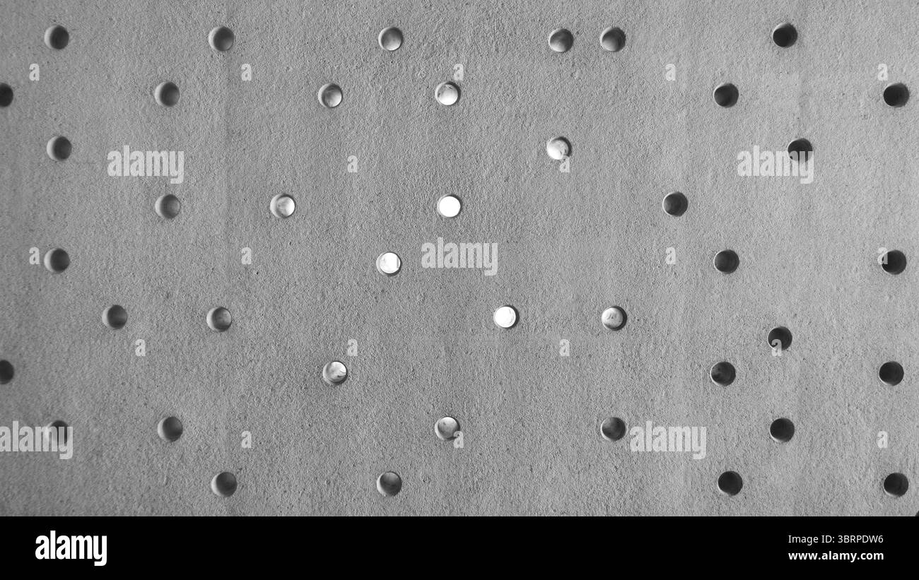 Rohbetonwand mit Perforationen, dekorative Betonfassade mit Löchern Stockfoto