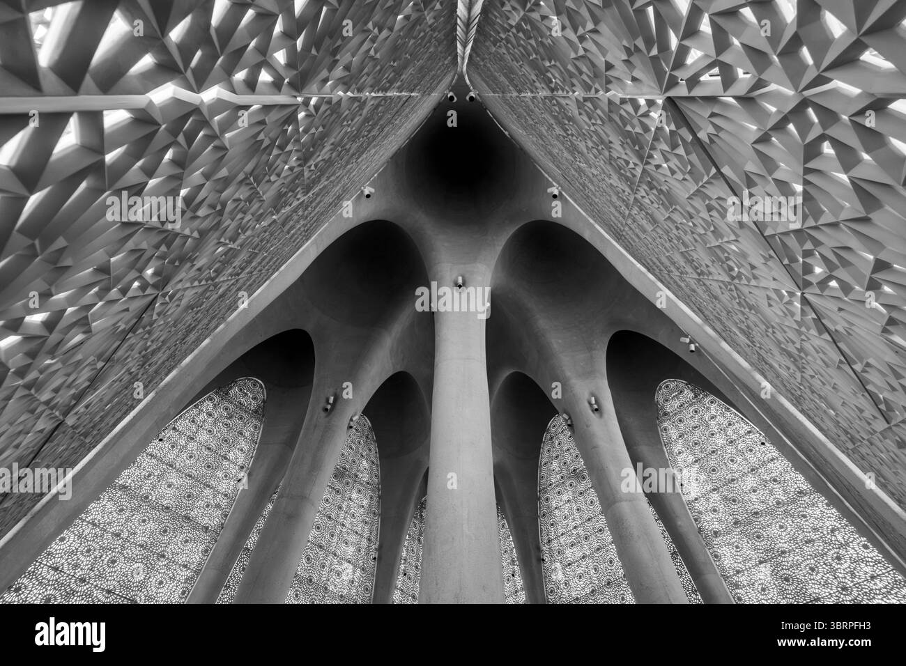 Architektonisches Wunder im Antonio-Gaudi-Stil mit geometrischer Decke und hoch aufragenden Säulen mit komplexen Mustern. Stockfoto Architektonisches Wunder im Antonio-Gaudi-Stil mit geometrischer Decke und hoch aufragenden Säulen mit komplexen Mustern. Stockfoto