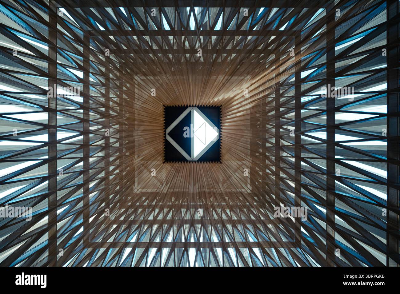 Geometrische Decke mit dreieckigen Mustern und einem zentralen, diamantförmigen Oberlicht für natürliches Licht Stockfoto