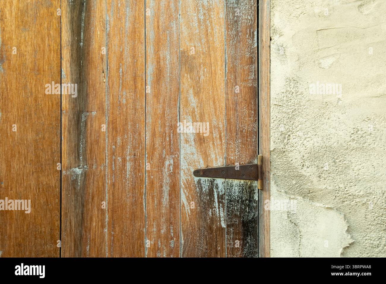 Alte Holztür mit eisernem Griff, traditionelle Vintage Holztür mit abgebrochener Farbe und robuster Textur Stockfoto