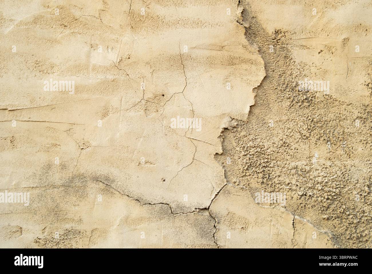 Hintergrund der alten Gebäudewand mit abgebrochenen Farben und Putzrissen, Kalksteinwand mit Rissen Stockfoto
