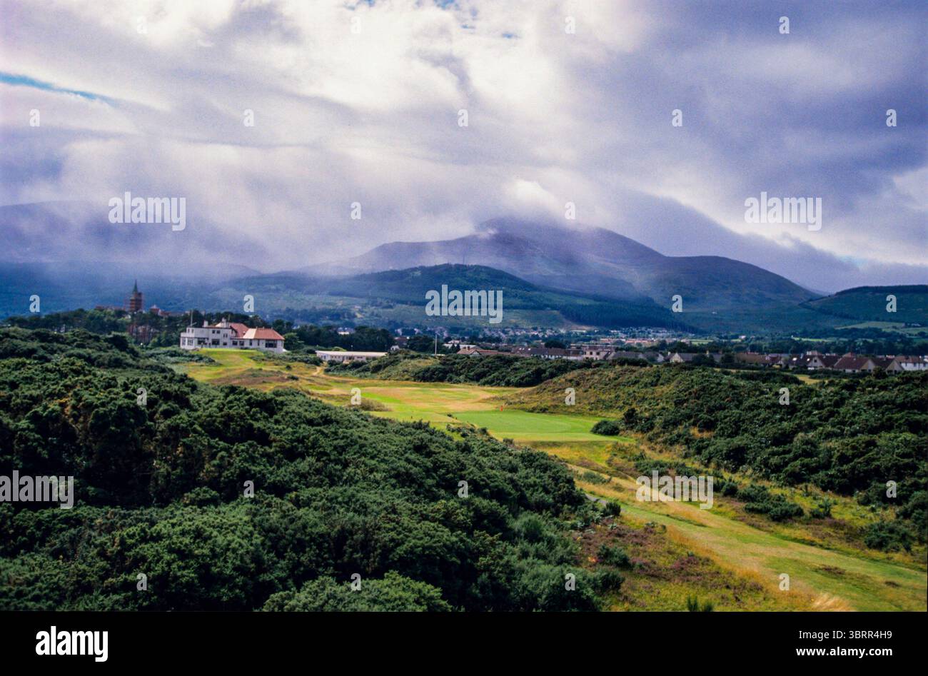 940911/ROYAL COUNTY DOWN GC/FOTOSHOOTING NEWCOMBE Hole by Hole der Royal County Down Golf Club ist einer der weltweit angesehensten und atemberaubendsten Golfplätze, vor der atemberaubenden Kulisse der Mourne Mountains in Nordirland. Der 1889 gegründete Championship Links Course ist bekannt für seine zerklüfteten Dünen, schnell laufenden Fairways und teuflisch kniffligen Pot Bunker, die einen reinen und aufregenden Golftest bieten. Mit seinen legendären blinden Abschlägen, hügeligen Grüns und den sich ständig ändernden Küstenwinden gehört Royal County Down immer wieder zu den besten Golfplätzen der Welt. Ein Dollar Stockfoto