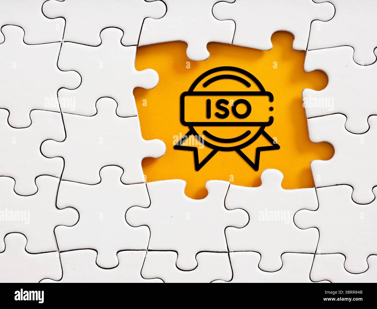 Puzzleteile mit leuchtendem gelbem Hintergrund und ISO-Zertifizierungssymbol. Stockfoto
