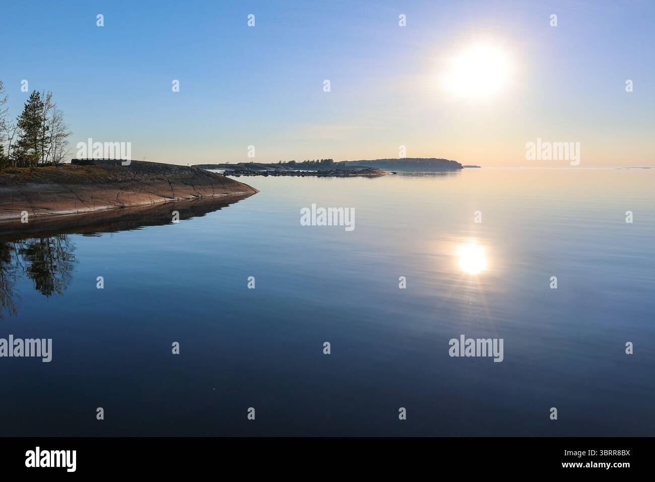 Felsige Inselchen im nördlichen Teil der Insel Ulko-Tammio an einem hellen, aber trüben Frühlingstag. Sonnenlicht scheint durch den weichen Nebel. Stockfoto Felsige Inselchen im nördlichen Teil der Insel Ulko-Tammio an einem hellen, aber trüben Frühlingstag. Sonnenlicht scheint durch den weichen Nebel. Stockfoto
