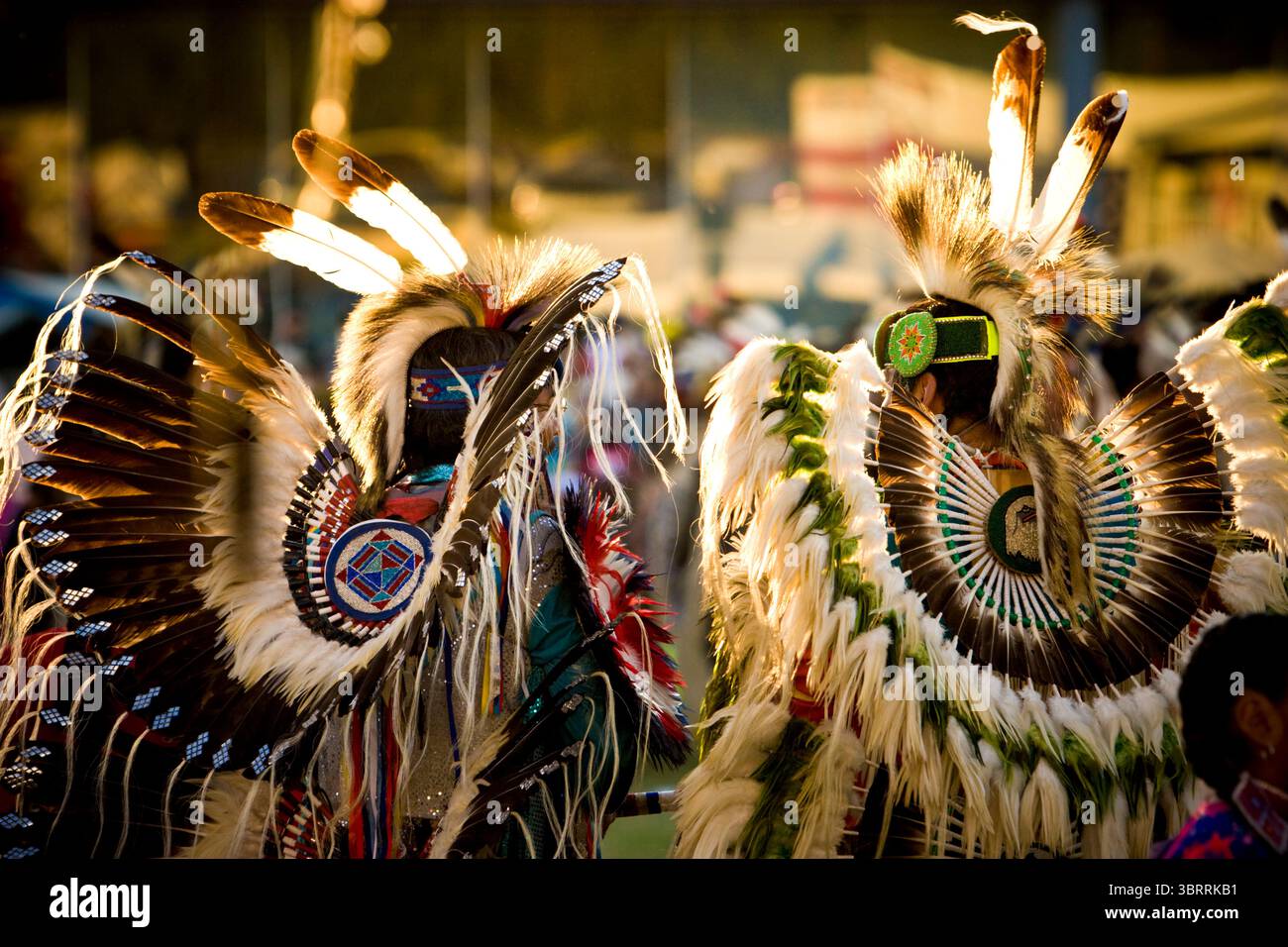 Zwei Indianer mit dem Rücken zur Kamera tragen bei einem Powwow in Post Fall, Idaho, aufwendige Kostüme. Stockfoto