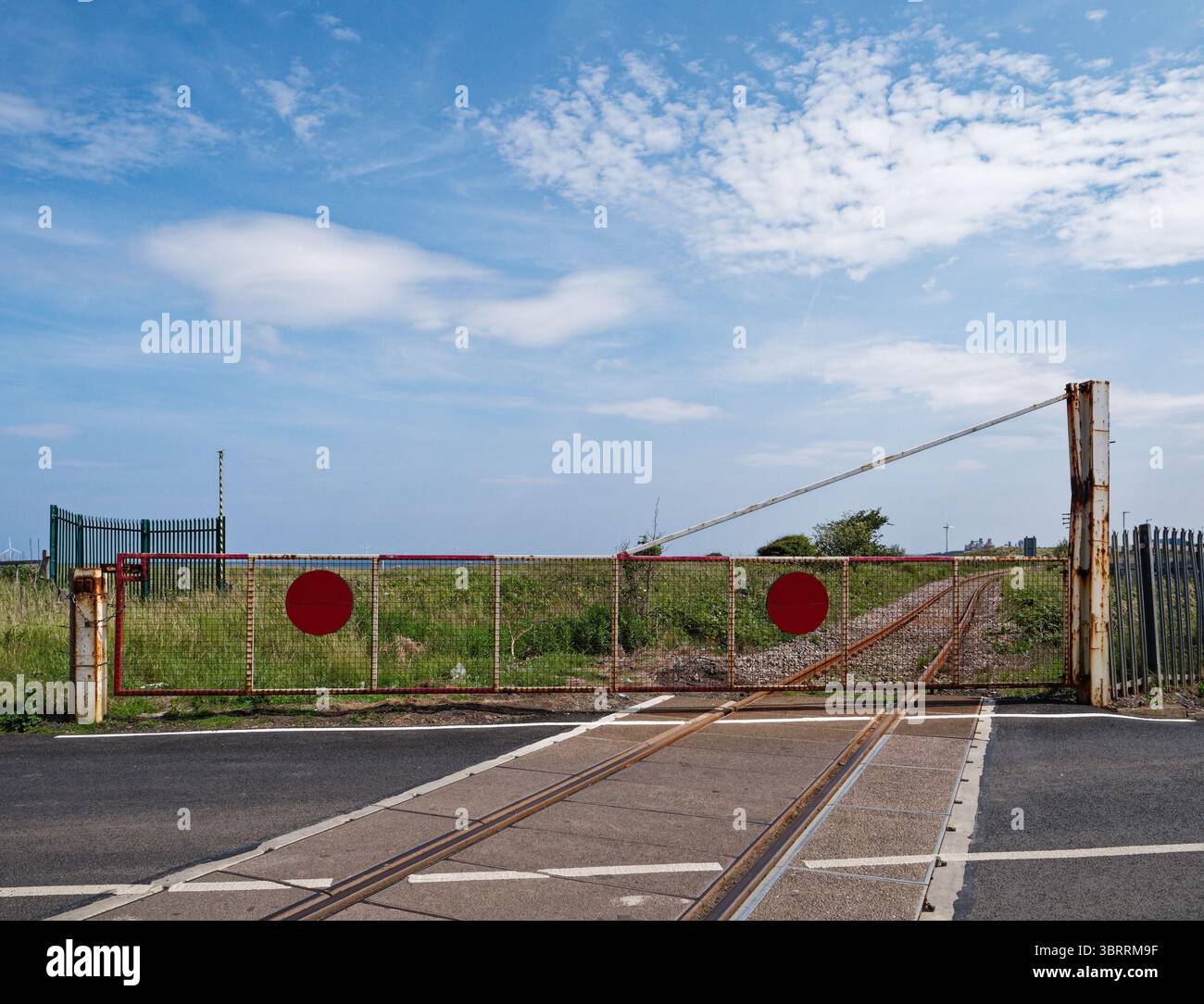 Bahnübergang mit geschlossenen Barrieren in North Blyth, Northumberland, Großbritannien. Stockfoto